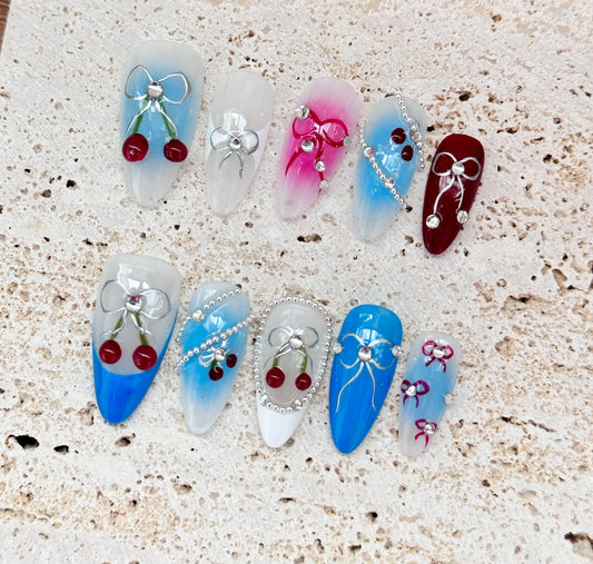 Cherry and Bow Nail Art Design with Gradient Blue and Pink Accents
