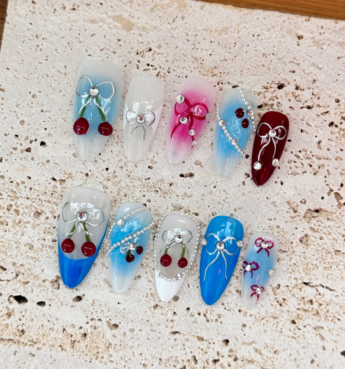 Cherry and Bow Nail Art Design with Gradient Blue and Pink Accents